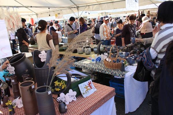 丹波焼陶器を手に取ってみている人々の写真